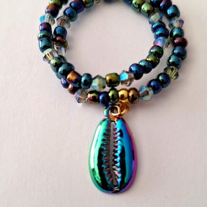 May include: A double-strand iridescent blue and green beaded bracelet with a iridescent blue seashell charm.