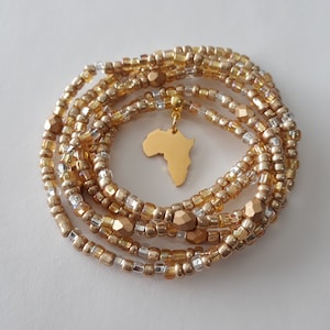 May include: Gold and silver beaded wrap bracelet with a gold charm in the shape of the continent of Africa.