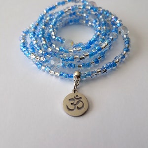 May include: A blue and silver beaded wrap bracelet with an Om symbol charm.