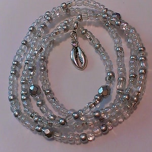 May include: A silver and clear beaded wrap bracelet with a silver seashell charm.