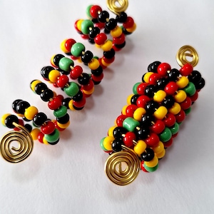 May include: Two gold hair coils with red, yellow, green, and black beads. The coils are made of wire and are designed to hold hair in place.