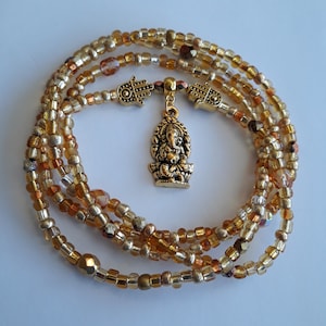 May include: A gold beaded waist chain with a gold Ganesha charm and two gold Hamsa charms.