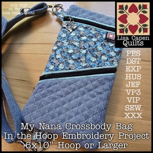 May include: A denim crossbody bag with a floral patterned top section and a black zipper. The bag is quilted and has a strap. Text on the bag reads "My Nana Crossbody Bag In the Hoop Embroidery Project 6x10" Hoop or Larger."