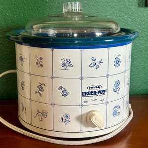 May include: A white ceramic mug with a black handle and the text "But First, Coffee" in a black, bold font. The mug is on a white surface. The mug appears to be 12 ounces.