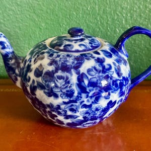 May include: A set of three ceramic mugs with a speckled, matte finish. The mugs are in shades of cream, light brown, and dark brown. Each mug has a simple, minimalist design, perfect for coffee or tea.