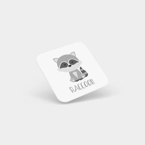 May include: A white square card with a cartoon gray raccoon illustration and the word "RACCOON" printed in black.