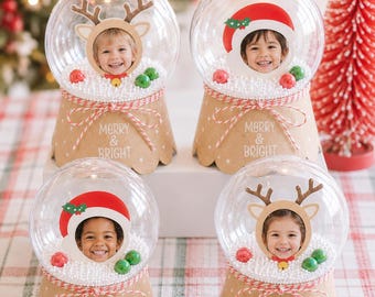 Könnte beinhalten: Vier durchsichtige Schneekugeln aus Kunststoff mit hellbraunen Sockeln, weißen Punkten und dem Text Merry & Bright. Jede Kugel enthält ein Kinderfoto, weiße Schaumstoffperlen sowie rote und grüne Kugeln. Zwei zeigen Rentiergeweihe.