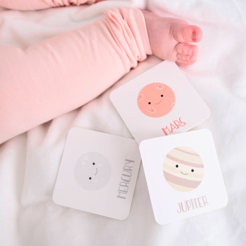 May include: Three illustrated flashcards featuring planets from our solar system. The cards are white with black text and colorful illustrations of Mercury, Mars, and Jupiter. Each planet has a smiling face.