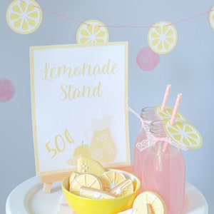 Pretend play lemonade stand setup for kids with printable awning, banner, and signage used to create a realistic role play experience that builds confidence and social interaction skills.