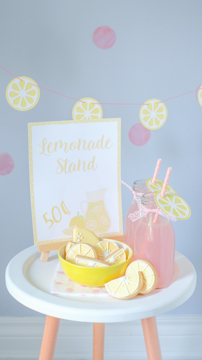 Pretend play lemonade stand setup for kids with printable awning, banner, and signage used to create a realistic role play experience that builds confidence and social interaction skills.