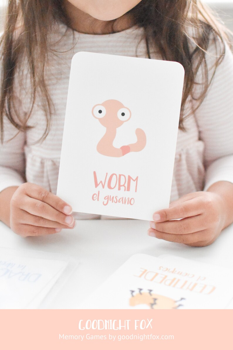 May include: A pink and white flashcard with a cartoon worm illustration. The card says "WORM" and "el gusano" in pink text.