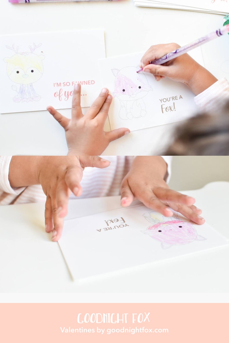 May include: Two blank Valentine's Day cards with a fox and a deer illustration. The cards have the text "You're a Fox!" and "I'm so fawned of you..." printed on them. A child is coloring the fox with a pink marker.