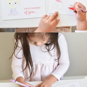 May include: A child colors a Valentine's Day card with a cartoon deer and the text "I'm so fawned of you..." The card is white with pink and purple accents.