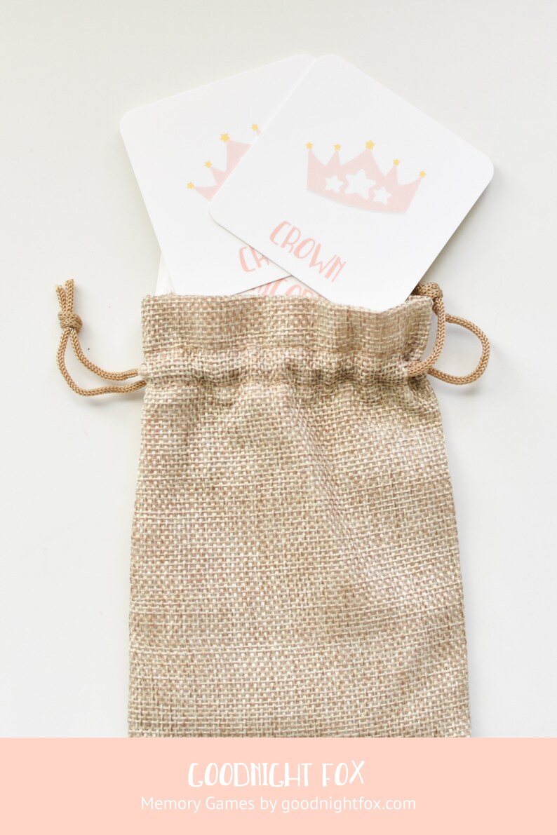 May include: A burlap drawstring bag with two white cards inside. The cards have pink crowns with gold stars on them. The text on the cards reads "CROWN".