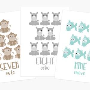 May include: Three white cards with illustrations of animals and numbers. The first card shows seven brown monkeys with tails, the second card shows eight gray rhinos, and the third card shows nine light blue fish. Each card has the number written in English and Spanish.