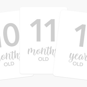 May include: Three white cards with gray numbers and text. The first card says "10 months old", the second card says "11 months old", and the third card says "1 year old".