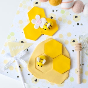 A toddler pretending to harvest honey using the bee-themed dramatic play printables and sensory tools.