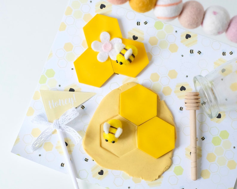 A toddler pretending to harvest honey using the bee-themed dramatic play printables and sensory tools.