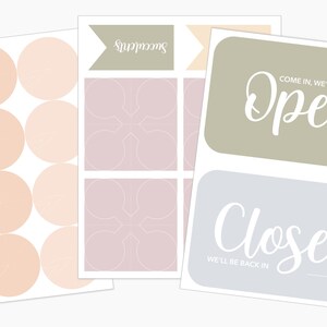 May include: A selection of stickers and signs in pastel shades. Features round stickers with a peach and white design, stickers with a geometric pattern, and signs that say "Open" and "Closed".