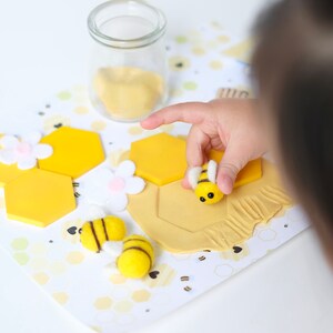 Bee keeper dramatic play printables displayed with Montessori tools like scoops, tongs, and color-sorting bowls.