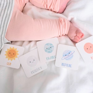 May include: A set of six colorful flash cards featuring illustrations of the sun and planets. The cards are white with black text and feature the names "Sun", "Mercury", "Uranus", "Neptune", and "Mars".