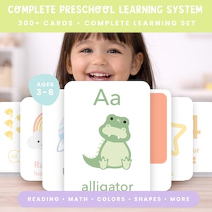 Op de afbeelding: Een voorschools leersysteem met flashcards met het alfabet en cijfers. De afbeelding toont een kind dat achter de kaarten lacht. De kaarten hebben illustraties van een alligator, een regenboog en andere educatieve afbeeldingen. De tekst bevat het woord "alligator".