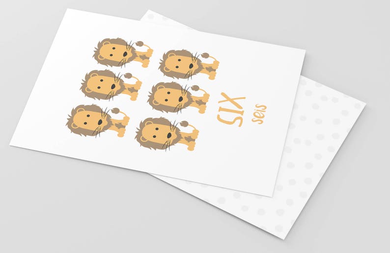May include: A white card with six cartoon lions in orange and brown. The card says "SIX" in orange letters and "seis" in smaller orange letters.