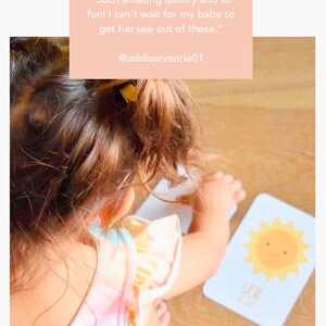 May include: A young child is playing with a weather-themed toddler flashcard set. The card features a yellow sun with a smiling face. The text on the card reads "Sun". The caption on the image reads "Goodnight Fox Weather toddler gift set by goodnightfox.com".