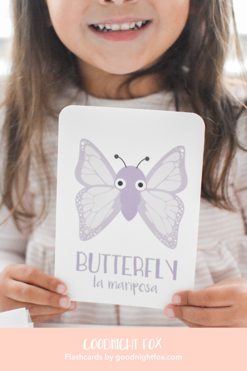 May include: A purple butterfly with large eyes on a white flashcard. The card also includes the word "BUTTERFLY" and the Spanish translation "la mariposa".