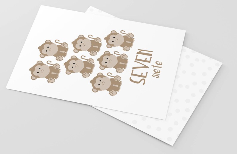 May include: A white card with seven brown monkeys holding sticks. The text "SEVEN siete" is printed on the card.