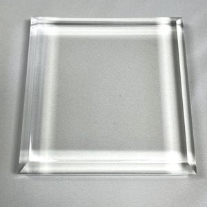 Può includere: Un blocco quadrato trasparente in acrilico con bordi smussati. Il materiale trasparente lascia passare la luce, creando un'estetica pulita e moderna. I bordi sono tagliati con precisione, mettendo in risalto la trasparenza del materiale. Ideale per esposizioni o scopi decorativi.