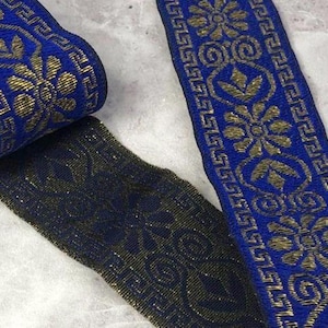 May include: A roll of blue and gold decorative ribbon with a floral and geometric pattern. The ribbon is approximately 1 inch wide and features a metallic gold design on a dark blue background. The ribbon is suitable for various craft projects.