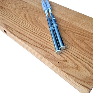 Pu&ograve; includere: Un ripiano in legno naturale con finitura marrone chiaro. Il ripiano ha due fori preforati e viene fornito con tre supporti per ripiani in metallo argentato.