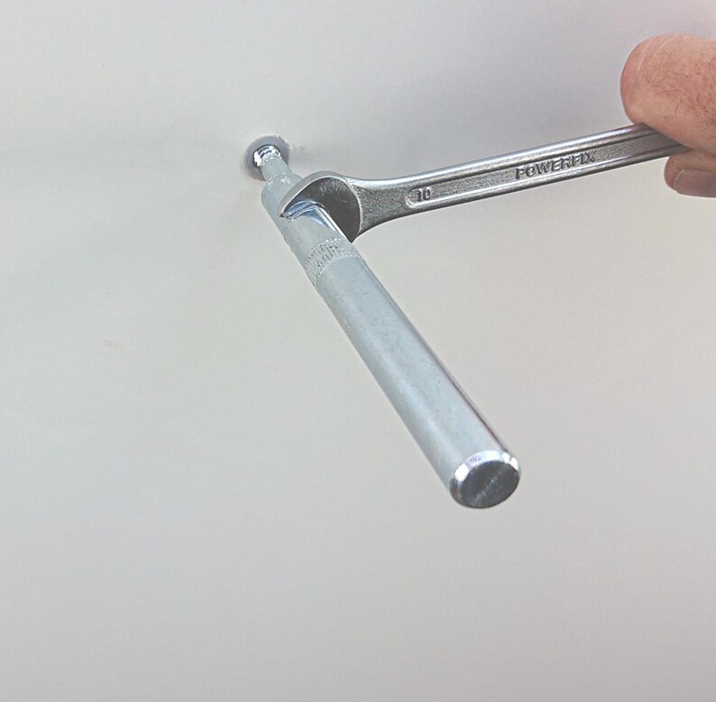 May include: A silver metal rod is being tightened with a wrench. The wrench is labeled "POWERFIX" and "10".