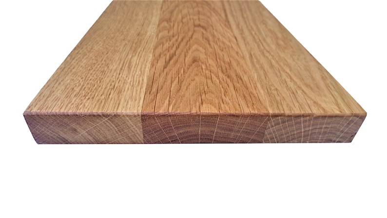 Pu&ograve; includere: Primo piano del bordo di una tavola di legno, che mostra la venatura del legno. La tavola &egrave; in rovere marrone chiaro e ha una finitura naturale.
