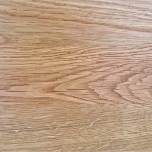 Pu&ograve; includere: Primo piano di una superficie di venatura del legno marrone chiaro con un piccolo nodo. Il legno ha un aspetto naturale e rustico.
