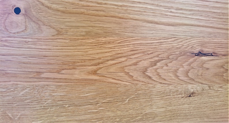 Pu&ograve; includere: Primo piano di una superficie di venatura del legno marrone chiaro con un piccolo nodo. Il legno ha un aspetto naturale e rustico.
