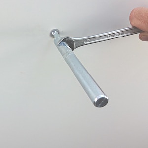 Pu&ograve; includere: Un'asta di metallo argentata viene stretta con una chiave. La chiave &egrave; etichettata "POWERFIX" e "10".