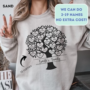May include: Sand-colored sweatshirt featuring a black family tree design with heart-shaped leaves, each bearing a name. The text "Smith's Family" is below the tree. The sweatshirt also has the text "WE CAN DO 2-19 NAMES NO EXTRA COST!" and "19 names".