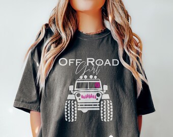 May include: A dark gray t-shirt with a white graphic of a jeep with the text "OFF ROAD Girl" above it. The jeep has pink accents.