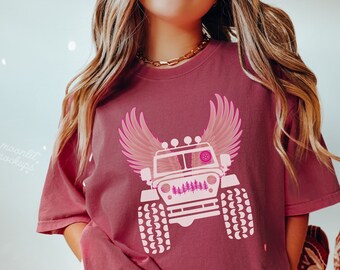 May include: A maroon t-shirt with a white graphic of a jeep with pink wings and trees on the front. The text "BRICK" is visible at the bottom of the image.