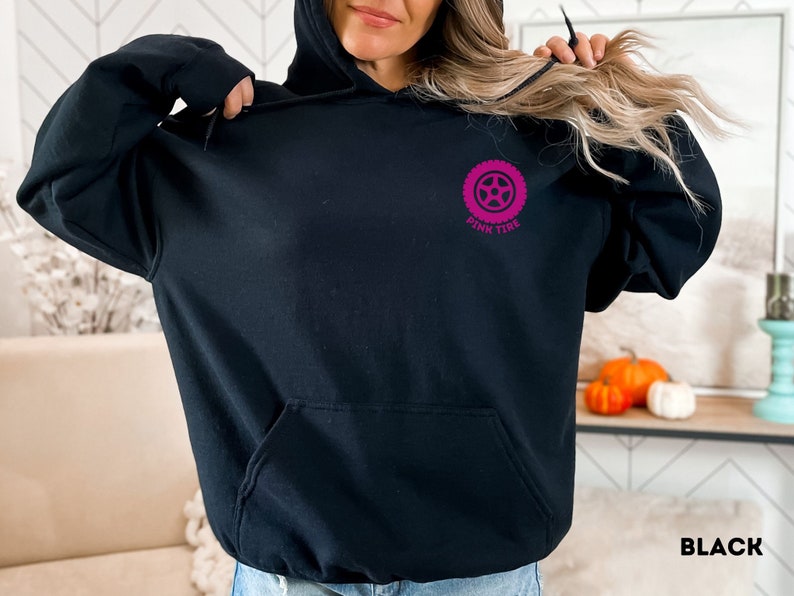K&ouml;nnte beinhalten: Schwarzer Hoodie mit einem rosafarbenen Reifen-Motiv und dem Text "Pink Tire" auf der Vorderseite.