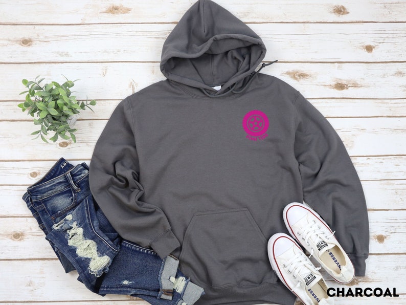 K&ouml;nnte beinhalten: Ein anthrazitfarbener Hoodie mit einem rosafarbenen Kreislogo, auf dem "Forever" steht. Der Hoodie hat eine Kapuze mit Kordelzug und eine K&auml;ngurutasche.