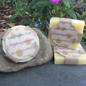 May include: Three bars of handmade soap with a brown paper label that reads "Daisy Hollow Farm Simply Lemongrass All-Natural Handmade Soap 3-3.5 oz".