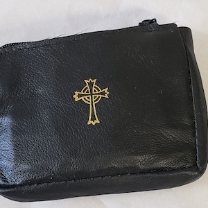 May include: Black leather pouch with a zipper closure and a gold Celtic cross design.
