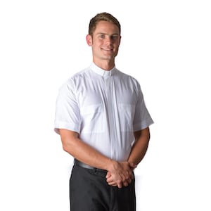May include: A white short-sleeved clergy shirt with a clerical collar and a single pocket on the left chest.