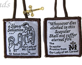 Może przedstawiać: Biały szkaplerz z brązowym obramowaniem, z haftowanym tekstem i ilustracjami. Z jednej strony napis „a Sign of Salvation”, z drugiej „Whosoever dies clothed in this Scapular”. Mały złoty krzyż wisi na brązowym sznurku.