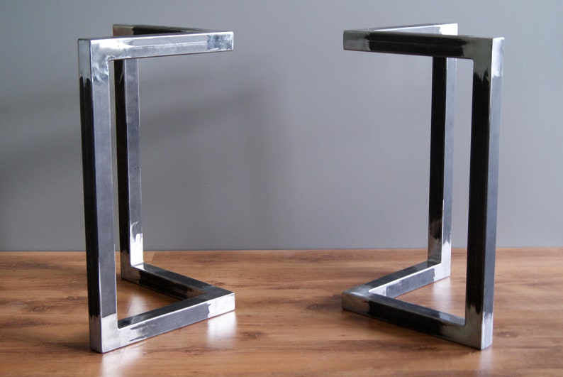 K&ouml;nnte beinhalten: Zwei schwarze Tischbeine aus Metall mit quadratischem Design. Die Beine sind aus dickem Metall gefertigt und haben eine geschwei&szlig;te Konstruktion.