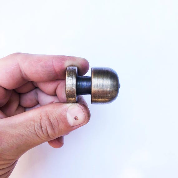A solid brass pull-string spinning top shaped like an old-school bomb — weighty, tactile, and has genuine antique workshop energy as a desk toy.