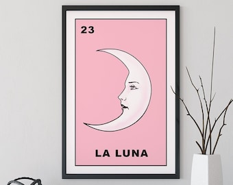 Könnte beinhalten: Ein gerahmter Kunstdruck mit rosa Hintergrund und einer weißen Mondsichel-Illustration, die ein menschliches Gesichtsprofil zeigt. Die Zahl 23 steht oben links und der Text LA LUNA ist unten in schwarzer Schrift aufgedruckt.